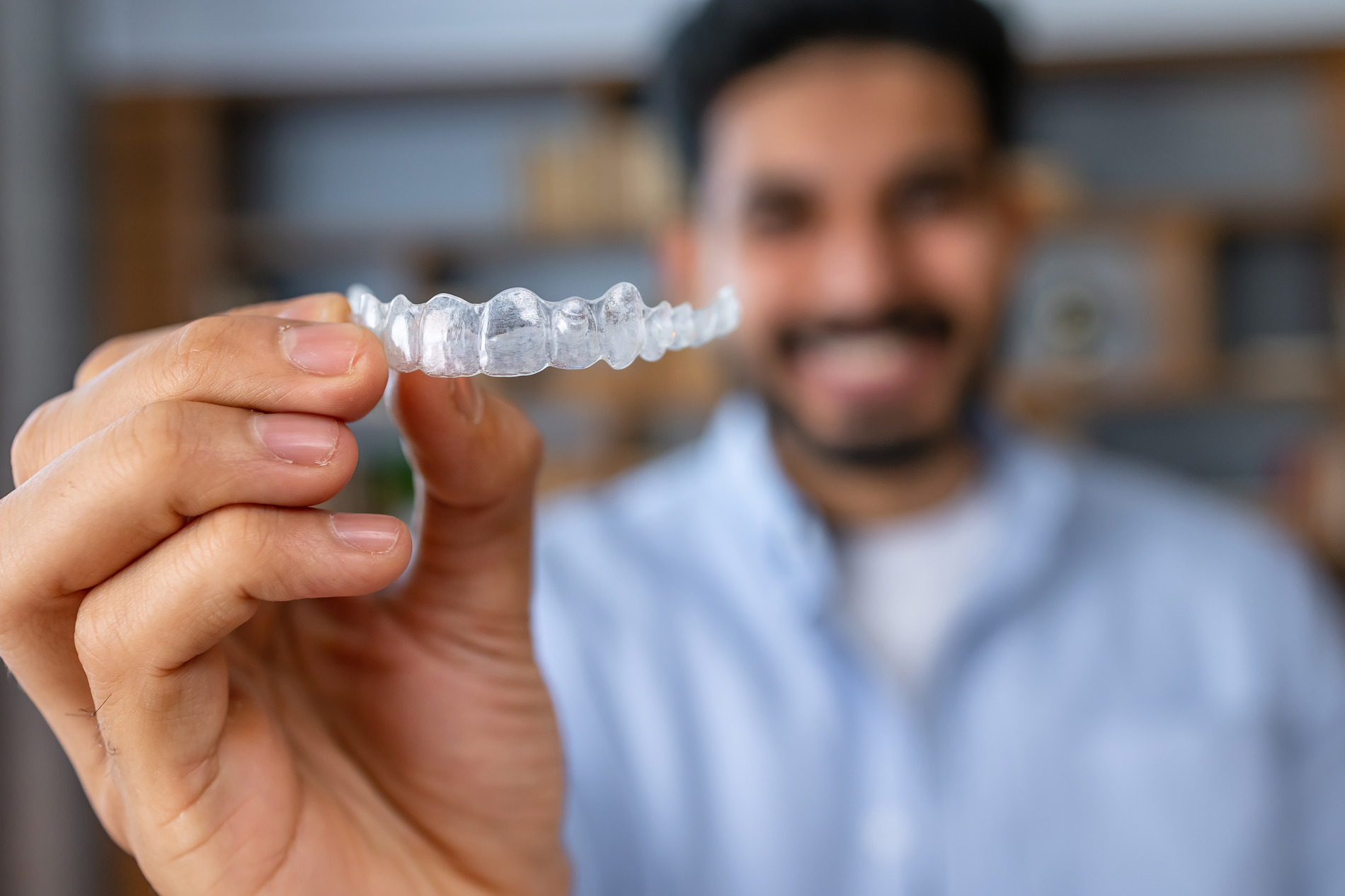 AdobeStock_610646852 v2 Man showing the camera his invisalign treatment from Dr. Rechtin & Dr. Jacobs in CrestView Hills