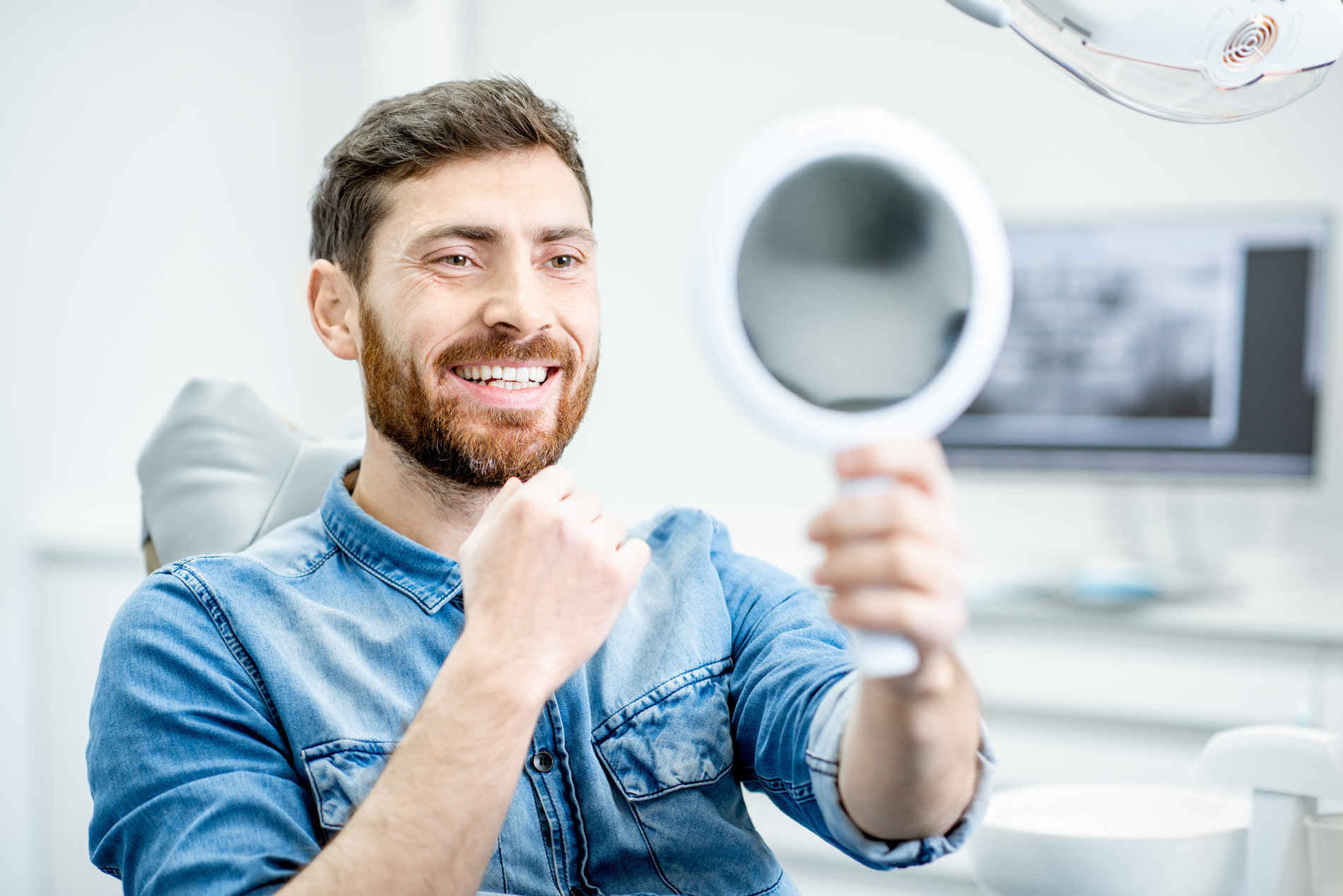 Man looking at his smile after surgical treatment orthodontics in Crestview Hills